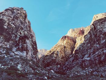 Low angle view of rocky mountains against sky