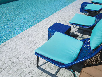 Empty chairs at swimming pool