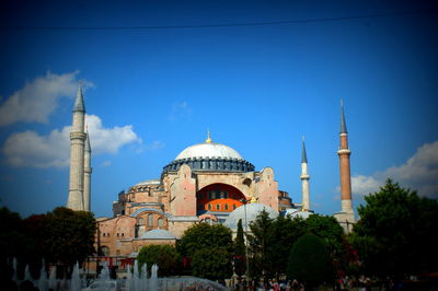 Panoramic view of buildings in city against blue sky