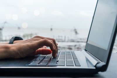 Close-up of person using laptop on table