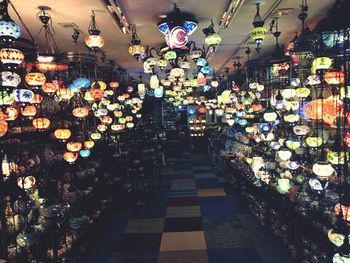 Illuminated lanterns hanging at market stall