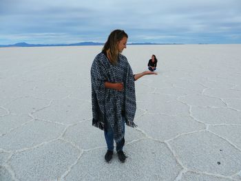 Two women creating optical illusion in desert