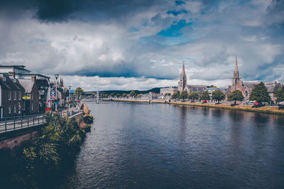 Bridge over river against buildings in city
