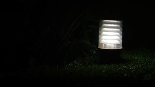 Illuminated lamp on field at night