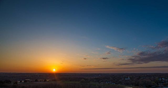 sunset, scenics, sun, tranquil scene, orange color, beauty in nature, tranquility, landscape, nature, idyllic, sky, silhouette, copy space, horizon over land, sunlight, clear sky, outdoors, field, no people, blue