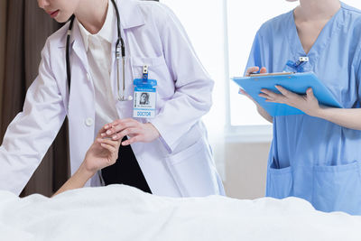 Midsection of doctor examining patient in hospital