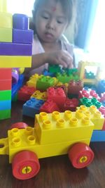 Cute boy playing with toy toys on table