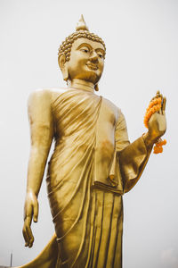 Low angle view of statue against temple against sky