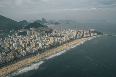 High angle view of sea and buildings against sky