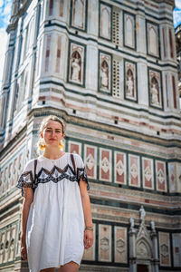 Low angle view of woman standing against building