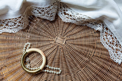 Detail of woven wrinker table with tablecloth, a bracelet and a necklace