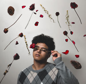 Portrait of young man standing against wall