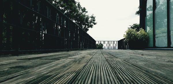 Surface level of empty footpath amidst buildings in city