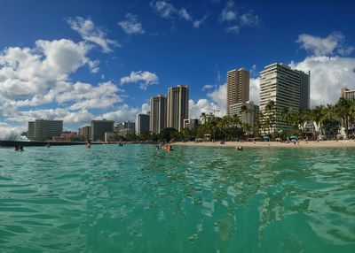 Sea by swimming pool against buildings in city