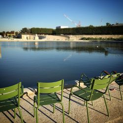 Chairs on shore against sky