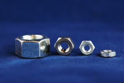 Close-up of steel nuts on blue background