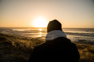 Rear view of man on beach during sunset