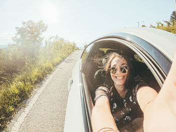 Portrait of smiling woman on road against sky