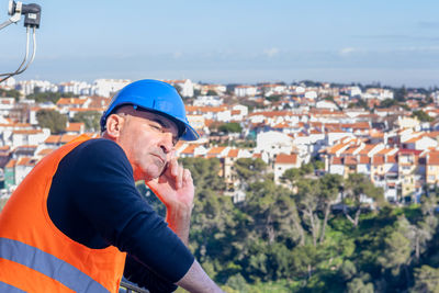 Side view of man looking at cityscape