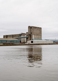 Buildings by sea against sky