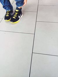 Low section of woman standing on tiled floor