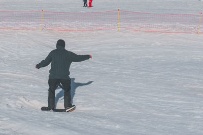 Full length of woman skiing on snow covered field