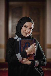 Portrait of young woman reading book