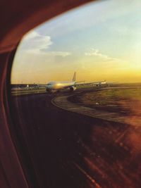 View of airport runway seen through airplane window