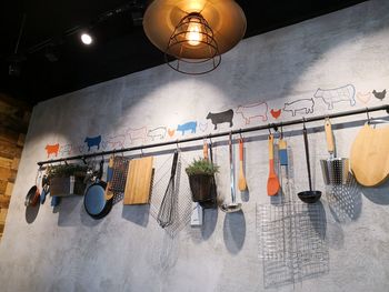 Low angle view of illuminated pendant lights hanging on wall