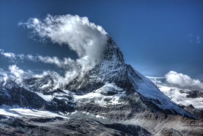 Snow covered mountain against cloudy sky