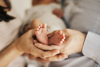 Parents holding newborn baby feet in hands