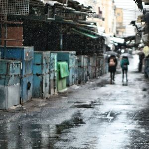 Man walking on road along buildings