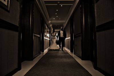 Rear view of people walking in corridor of building