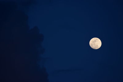 Low angle view of moon against blue sky