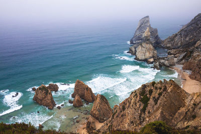 Scenic view of rocks in sea against sky