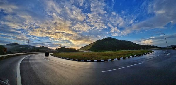 Road amidst landscape against sky during sunset