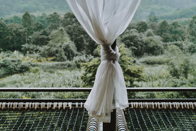 White curtain over metal against trees