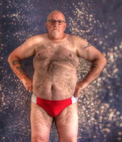 Midsection of shirtless man standing outdoors