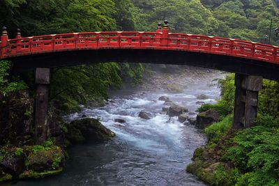Shinkyo bridge over the daiwa river in nikko outside of tokyo, japan in summer with cloud cover asia