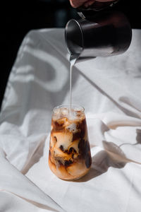 Close-up of hand pouring coffee in cup