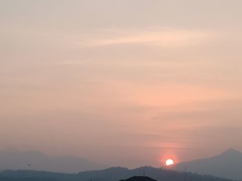 Scenic view of silhouette mountains against romantic sky at sunset