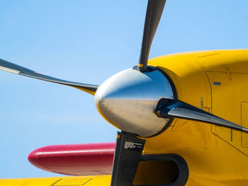 Close-up of airplane against clear blue sky