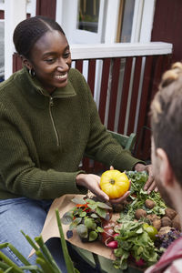 Smiling woman holding tomato