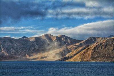 Scenic view of sea and mountains against sky