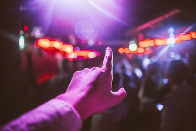 Close-up of hand pointing at illuminated lights in nightclub