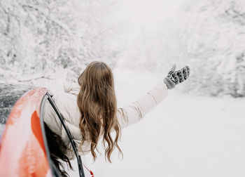 Rear view of woman standing in snow