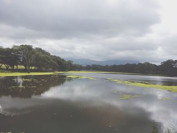 Scenic view of lake against cloudy sky