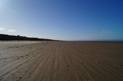 Scenic view of beach against blue sky