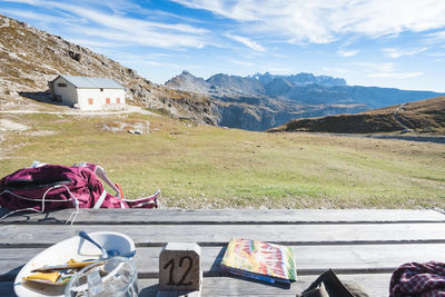 Lounge chairs on field by mountains against sky