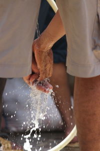 Midsection of man working in water